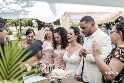 Foto da família dos noivos no altar recebendo as bençãos no casamento registrado pelo fotográfo de casamentos em BH, Rapha Drummond.'