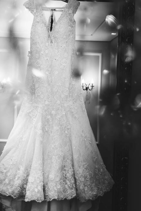 Fotografia do vestido da noiva em preto e branco, com ar dramático, tirada pelo fotógrafo de casamentos em BH, Rapha Drummond.'