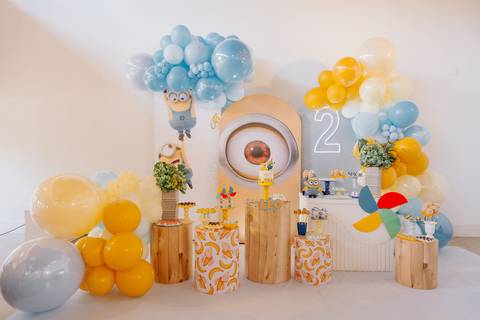 Painel decorativo com balões azuis e amarelos e elementos da festa infantil'