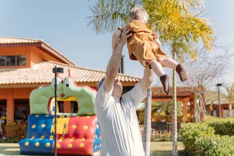 Léo sendo levantado no ar no jardim do condomínio'