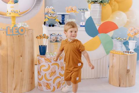 Léo explorando a decoração colorida da festa infantil no condomínio'