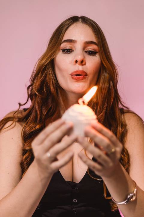 aniversariante-assoprando-vela-bolo-de-cupcake'