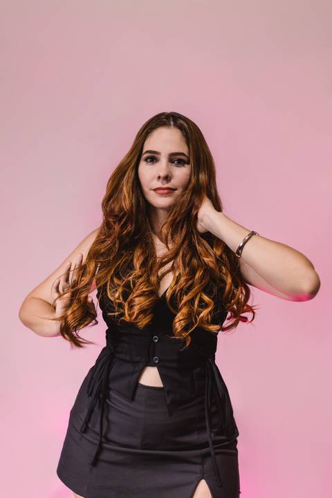 aniversariante-sorrindo-parada-de-frente-em-pose-mais-espontanea-mexendo-no-cabelo'