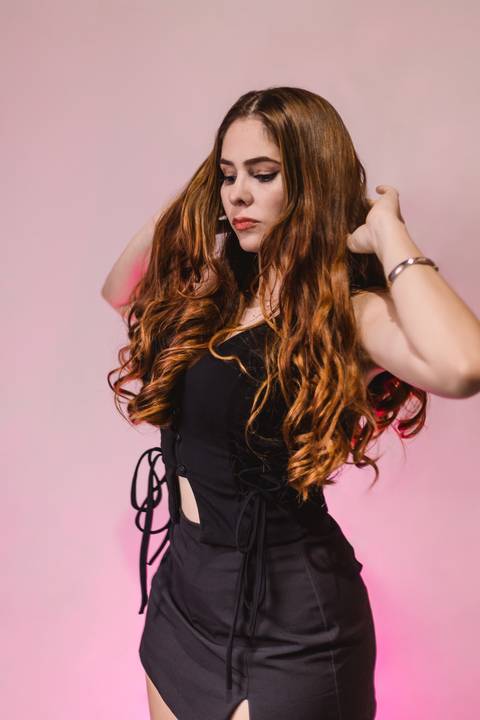 aniversariante-bem-séria-parada-de-lado-em-pose-mais-espontanea-mexendo-no-cabelo'