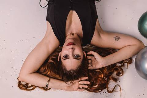 aniversariante-deitada-no-chao-com-as-maos-apoiadas-no-cabelo'