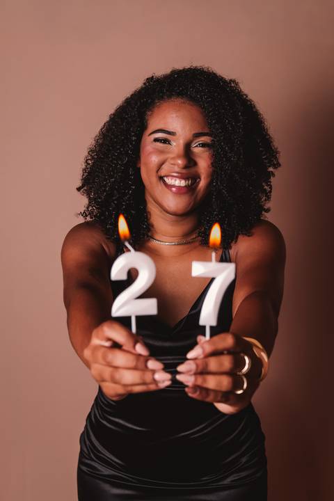 foto de uma mulher se sentindo linda com as velinhas de bolo acesas comemorando seu aniversário'