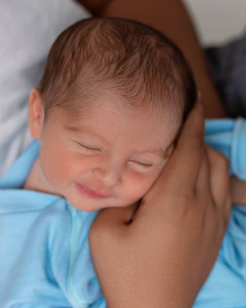 Ensaio Newborn Natal. Foto de recém-nascido com as mãos da família.'