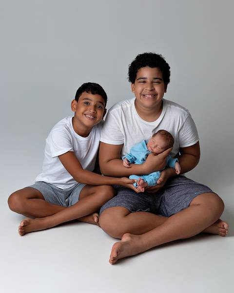 Ensaio de recém-nascido em Natal. Foto de bebê com os irmãos mais velhos.'