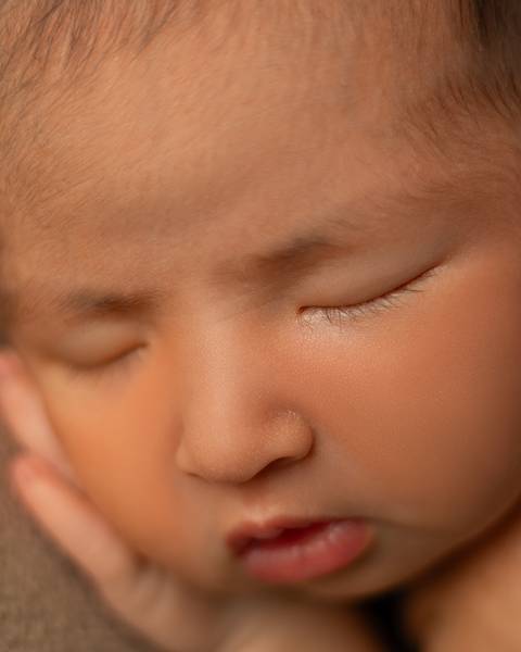 Close do rosto de bebê em ensaio Newborn atemporal. '