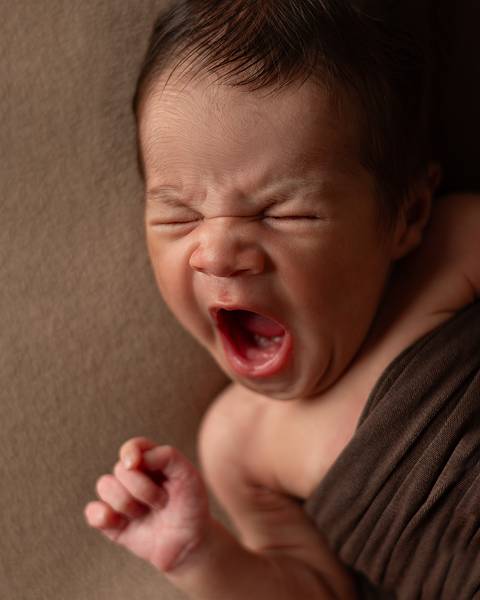 Bebê recém-nascido em ensaio newborn. Bebê bocejando.'