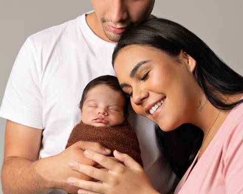 Bebê recém-nascido em ensaio Newborn com o pai e a mãe.'