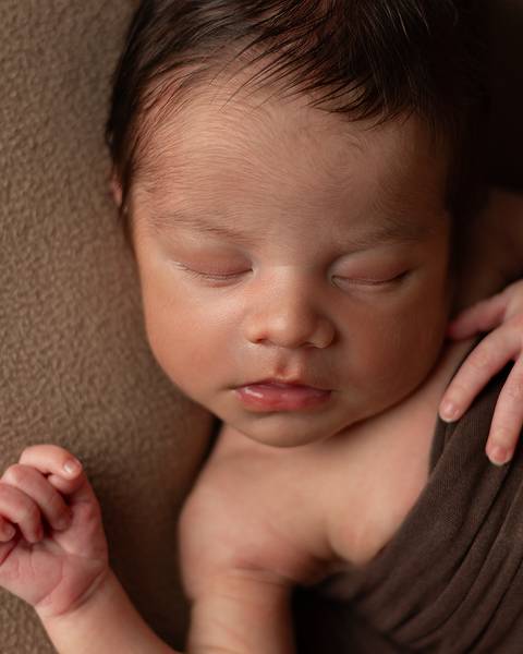 Bebê recém-nascido em ensaio newborn. Bebê dormindo tranquilamente.'