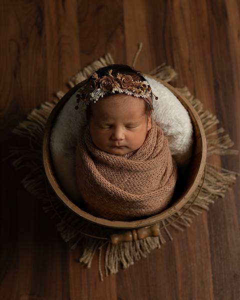 Bebê enrolada no Wrap dentro de um baldinho em ensaio Newborn aconchegante em Natal/RN, feito por Léo e Gabi da Amoradia.'
