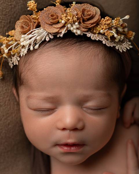 Ensaio Newborn em Estúdio. Menina recém-nascida com coroa de flores'