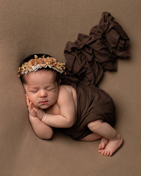 Ensaio Newborn em Estúdio. Menina recém-nascida com coroa de flores'