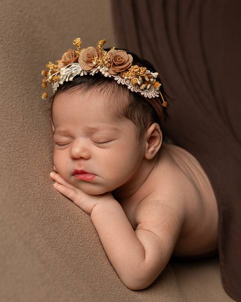 Ensaio Newborn em Estúdio. Menina recém-nascida com coroa de flores'
