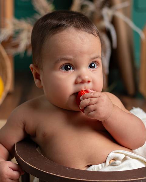 Ensaio em estúdio. bebê comendo frutinha'