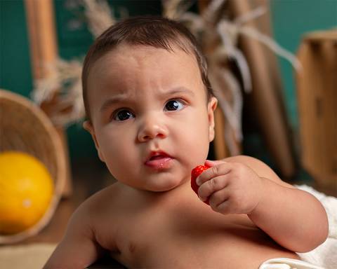 Ensaio em estúdio. bebê comendo frutinha'