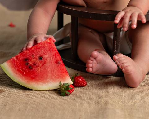 Ensaio em estúdio. bebê comendo frutinha'