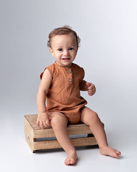 Ensaio de acompanhamento mensal de bebê em estúdio.'