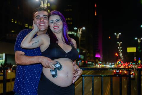 casal com sapatinho do bebe na avenida paulista em ensaio gestante noturno'