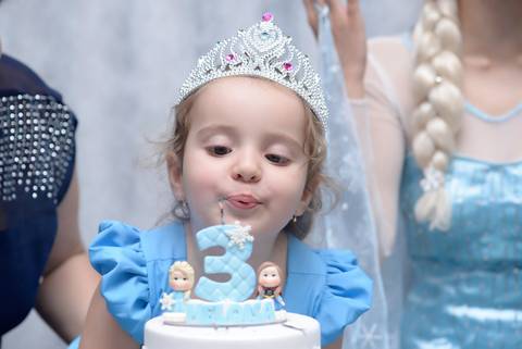 Criança fazendo biquinho para assoprar a vela, cobertura fotografica infantil.  aniversario em salão de festas, fotografa aniversario no tatuape'