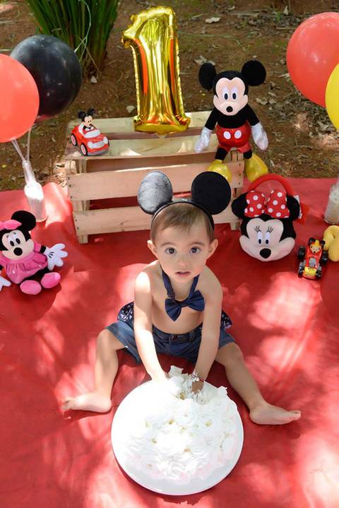 criança olhando pra cima no ensaio Smash the cake tema mickey no parque, decoraçao com as cores do tema, fotografa smash mooca'