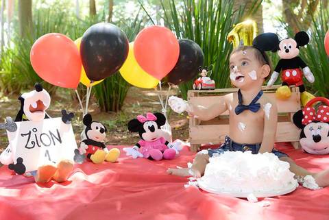 criança brincando com bolo no ensaio Smash the cake tema mickey no parque, decoraçao com as cores do tema, fotografa infantil mooca e regiao'