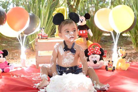 bebe melecado de bolo no ensaio Smash the cake tema mickey no parque, decoraçao com as cores do tema, fotografa smash e infantil tatuape e regiao'