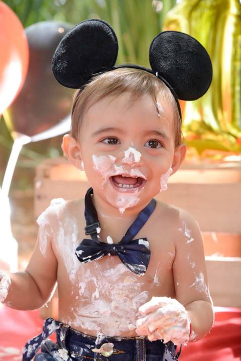 bebe dando risada no ensaio Smash the cake tema mickey no parque, decoraçao com as cores do tema, fotografa smash e infantil mooca e regiao'