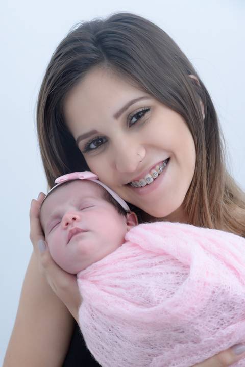 Bebe enrolado no wrap no colo da mamae sorrindo, ensaio newborn em casa, foto com os pais, fotografa newborn no tatuape, newborn menina'
