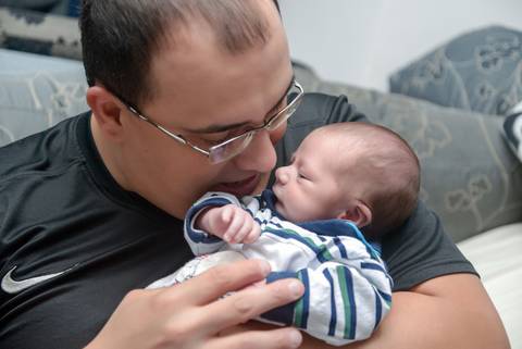bebe dormindo no colo do papai no ensaio newborn lifestyle, ensaio recem nascido em casa, fotografa newborn no Tatuapé, newborn menino'