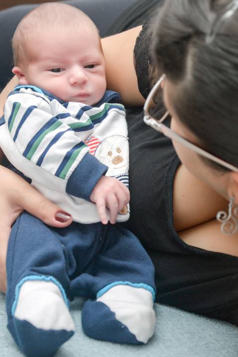 mamae com bebe olhos abertos na cama, ensaio newborn lifestyle, ensaio recem nascido em casa, fotografa newborn no Tatuape'