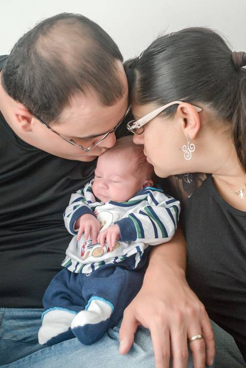 Foto com os pais beijando cabecinha do recem nascido, newborn menino, ensaio lifestyle, ensaio recem nascido em casa, fotografa newborn no Tatuape'