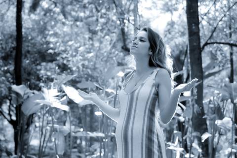 Foto preto e branco gestante agradecendo em meio a natureza, ensaio gravida externo, ensaio gestante jovem, fotografa tatuape. Fotos Gestante iluminaçao de cinema.'