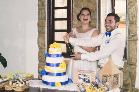 noivos abrindo champanhe na mesa do bolo em casamento rustico no sitio '
