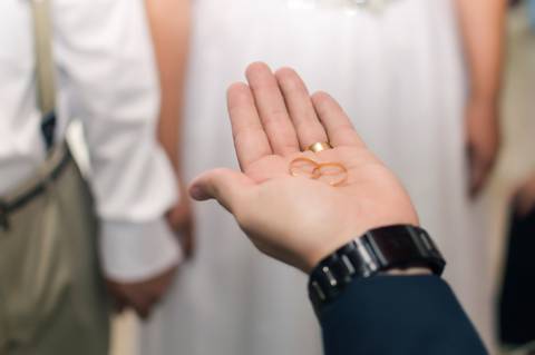 alianças na mão do celebrante sendo abençoadas '