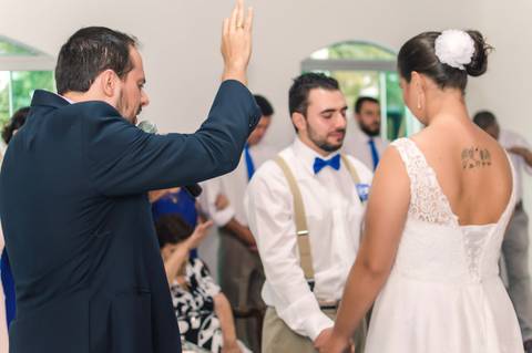 celebrante abençoando noivos no altar da capela'