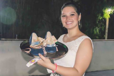 noiva com dinheiro arrecadado ao passar o sapato entre os convidados no casamento rustico'