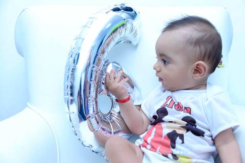 Acompanhamento de bebe na poltrona do quarto, foto do  bebe com balão numero 6. Ensaio 6 meses. Mesversário. Fotografa tatuape.  Ensaio infantil em casa ou estudio'