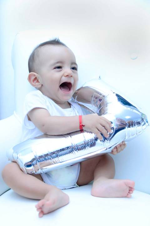Acompanhamento de bebe na poltrona do quarto, foto do  bebe com balão numero sete. Ensaio 7 meses. Mesversário. Fotografa tatuape.  Ensaio infantil em casa ou estudio'