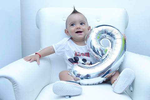 Acompanhamento de bebe na poltrona do quarto, foto do  bebe com balão numero nove. Ensaio 9 meses. Mesversário. Fotografa tatuape.  Ensaio infantil em casa ou estudio'