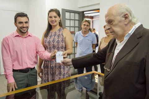 noivos com juiz do cartorio mostrando certidao de casamento'
