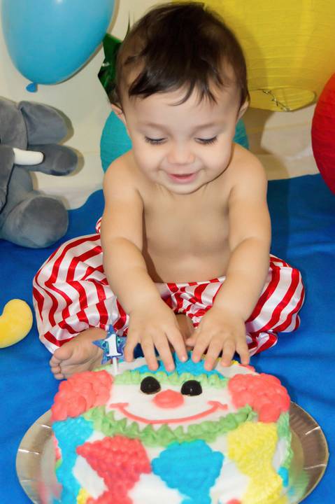 bebe colocando a mao no bolo em ensaio smash the cake'