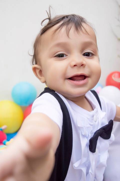 bebe tentando pegar a camera do fotografo em ensaio infantil'