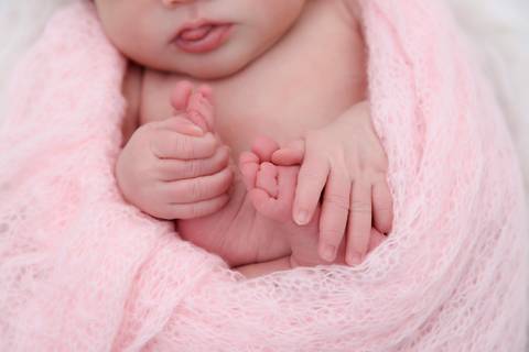 fotografa newborn tatuape, bebe segurando pezinho em ensaio fotografico'