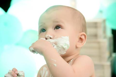 foto de close do bebe comendo bolo, smash the cake externo no parque ibirapuera'