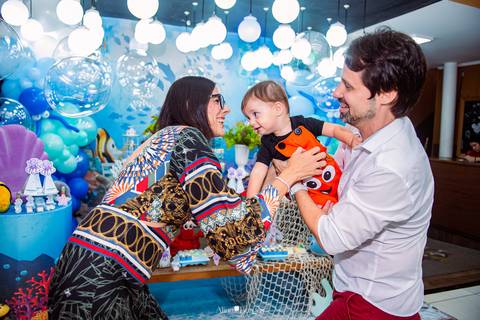 criança comemorando aniversário de 1 ano com os pais em festa infantil tema fundo do mar'