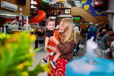 avó interagindo com criança durante aniversário infantil em festa tema fundo do mar'