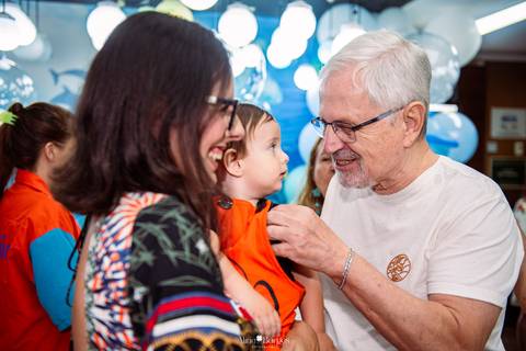 avô interagindo com criança durante aniversário infantil em festa tema fundo do mar'
